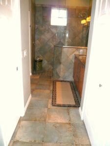 A walk in shower with tiled walls and floor.